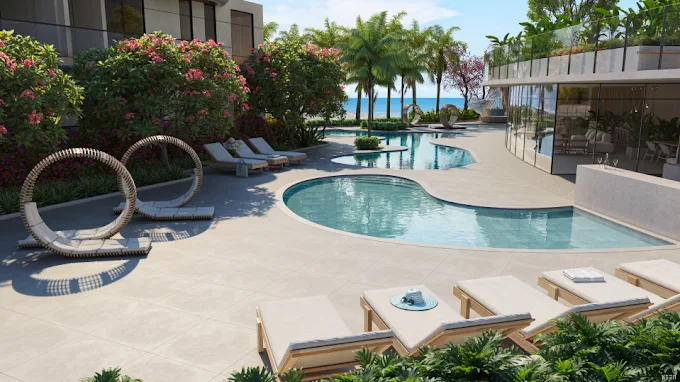 Área de lazer de luxo do Manami Ocean Living Guarapari com piscinas orgânicas, espreguiçadeiras e vista para o mar da Enseada Azul.
