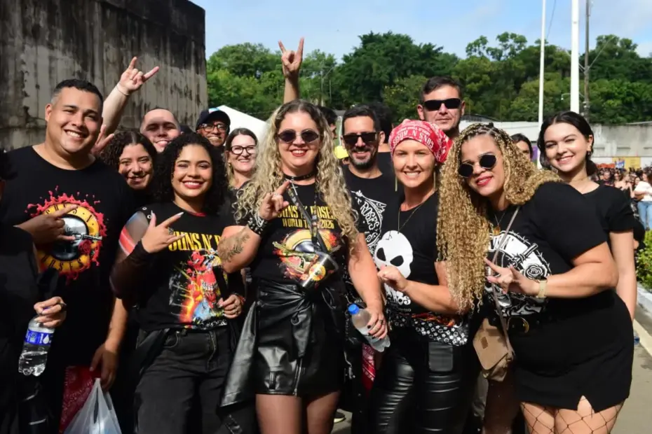Fãs sorridentes com camisetas da banda no show do Guns N' Roses no Kleber Andrade, otimizado por Especialista Raimundo Oliveira SEO RedeVix.