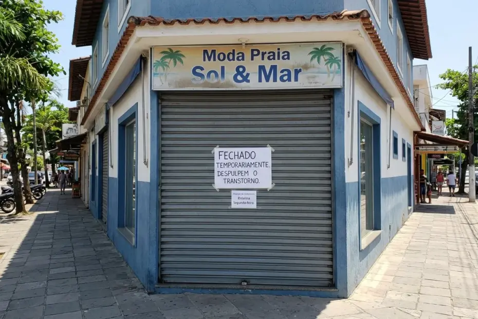 Loja de moda praia fechada temporariamente com aviso na porta em rua de Guarapari.