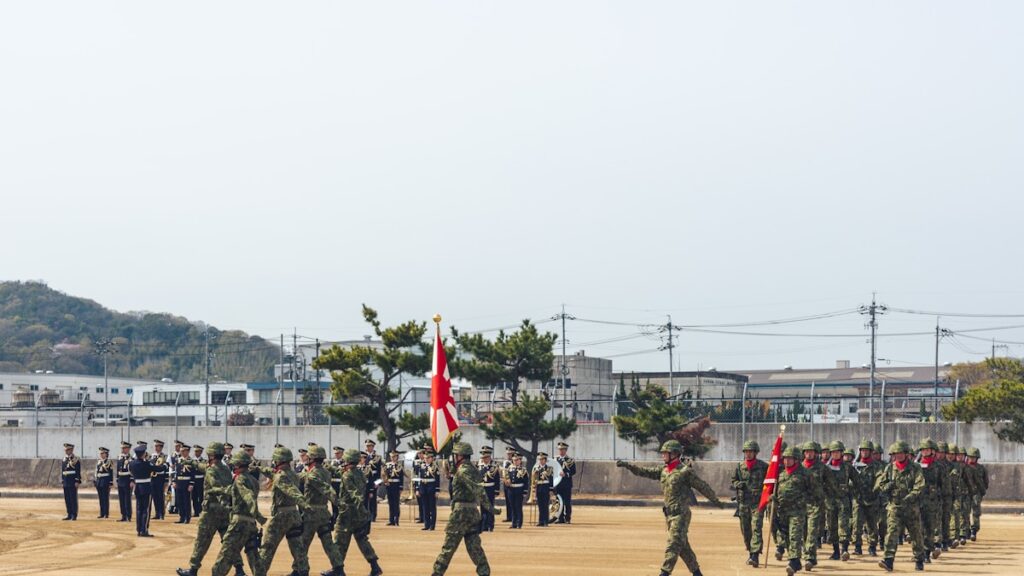 Japão exportação de armas — bandeira japonesa com equipamentos militares ao fundo