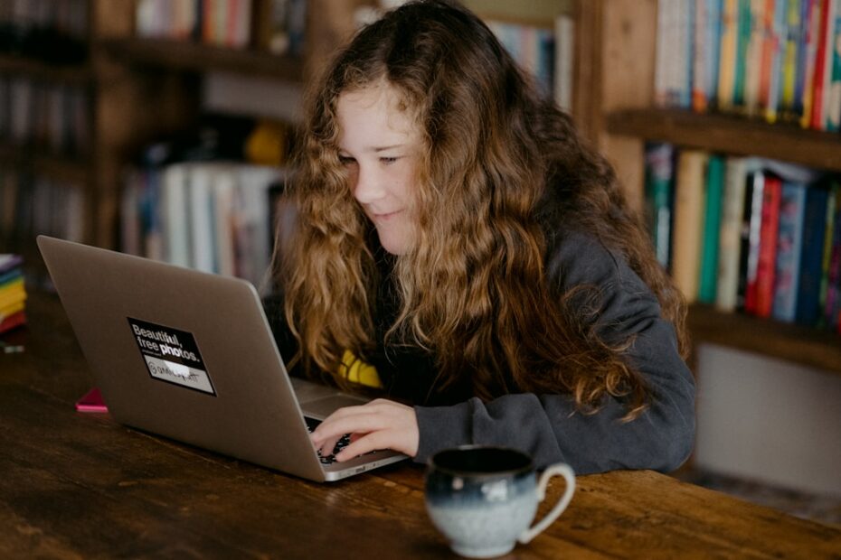Cursos Online — estudante assistindo aula pelo computador com fones de ouvido