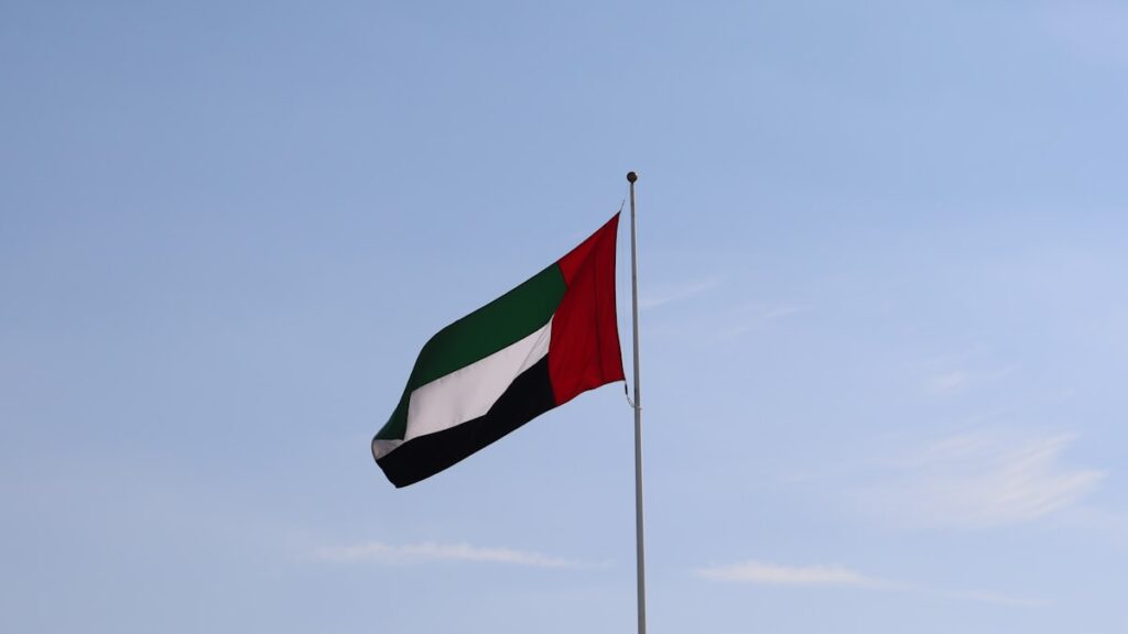 Emirados Árabes deixam Opep — bandeira dos EAU e barris de petróleo representando saída do cartel