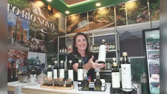 Imagem da Feira dos Municípios 2026 no Pavilhão de Carapina, exibindo a culinária capixaba com broa de melado e azeite de.
