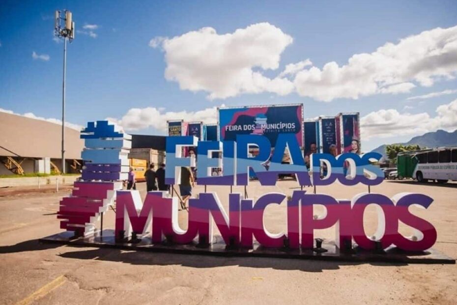 Imagem da Feira dos Municípios 2026: stands coloridos, música ao vivo e visitantes explorando a cultura capixaba na Serra.