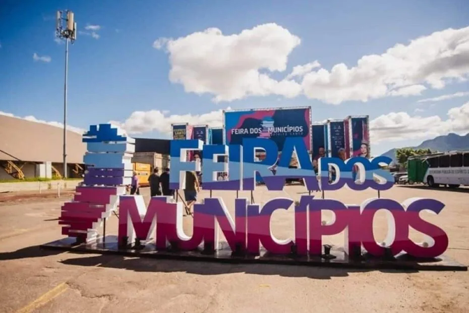 Imagem da Feira dos Municípios 2026: stands coloridos, música ao vivo e visitantes explorando a cultura capixaba na Serra.