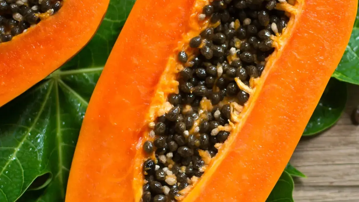 Imagem de mamão fresco cortado, destacando sua polpa laranja vibrante e sementes, simbolizando saúde e bem-estar.