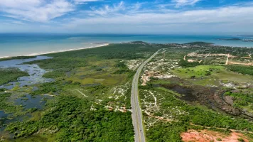 Imagem de reunião sobre o novo aeroporto de Guarapari, destacando investimentos de R$ 1 bilhão e desenvolvimento regional.