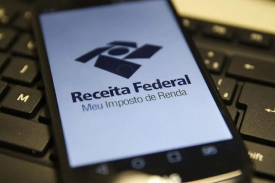 Imagem de uma calculadora e documentos fiscais, simbolizando a declaração do Imposto de Renda e a importância do prazo.