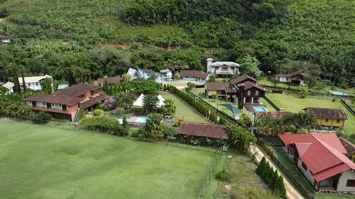 "Imagem do Arraiá da Pestalozzi com famílias reunidas, comidas típicas e música animada em Alfredo Chaves."