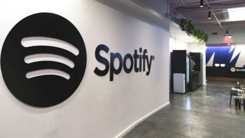 "Imagem do logo do Spotify com destaque para novas funcionalidades de audiolivros e reportagens em áudio."