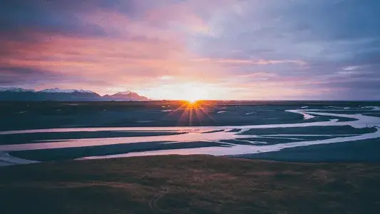 Pores do sol iluminando o horizonte em um cenário natural ao entardecer.