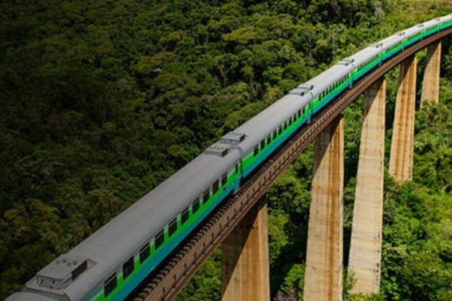 "Vista panorâmica do trem entre Belo Horizonte e Cariacica, destacando paisagens naturais e montanhas ao fundo."