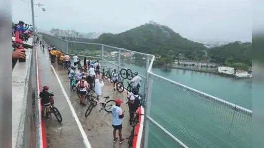 Ciclista utilizando bicicleta elétrica fora da ciclovia na Terceira Ponte, em Vitória.