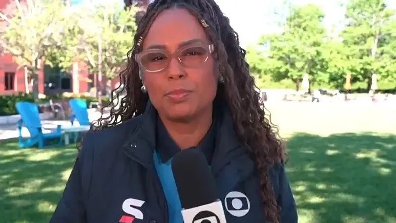 Karine Alves durante transmissão ao vivo no programa Bom Dia Brasil, abordando dificuldades de mulheres negras na imigração.