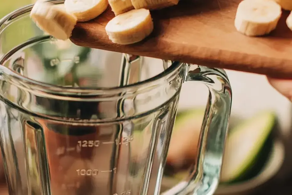 Vitamina de banana e aveia em um copo transparente sobre uma mesa de madeira.