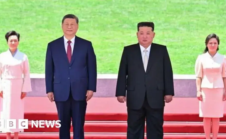 Xi Jinping e Kim Jong Un se cumprimentam durante a visita do presidente chinês a Pyongyang.